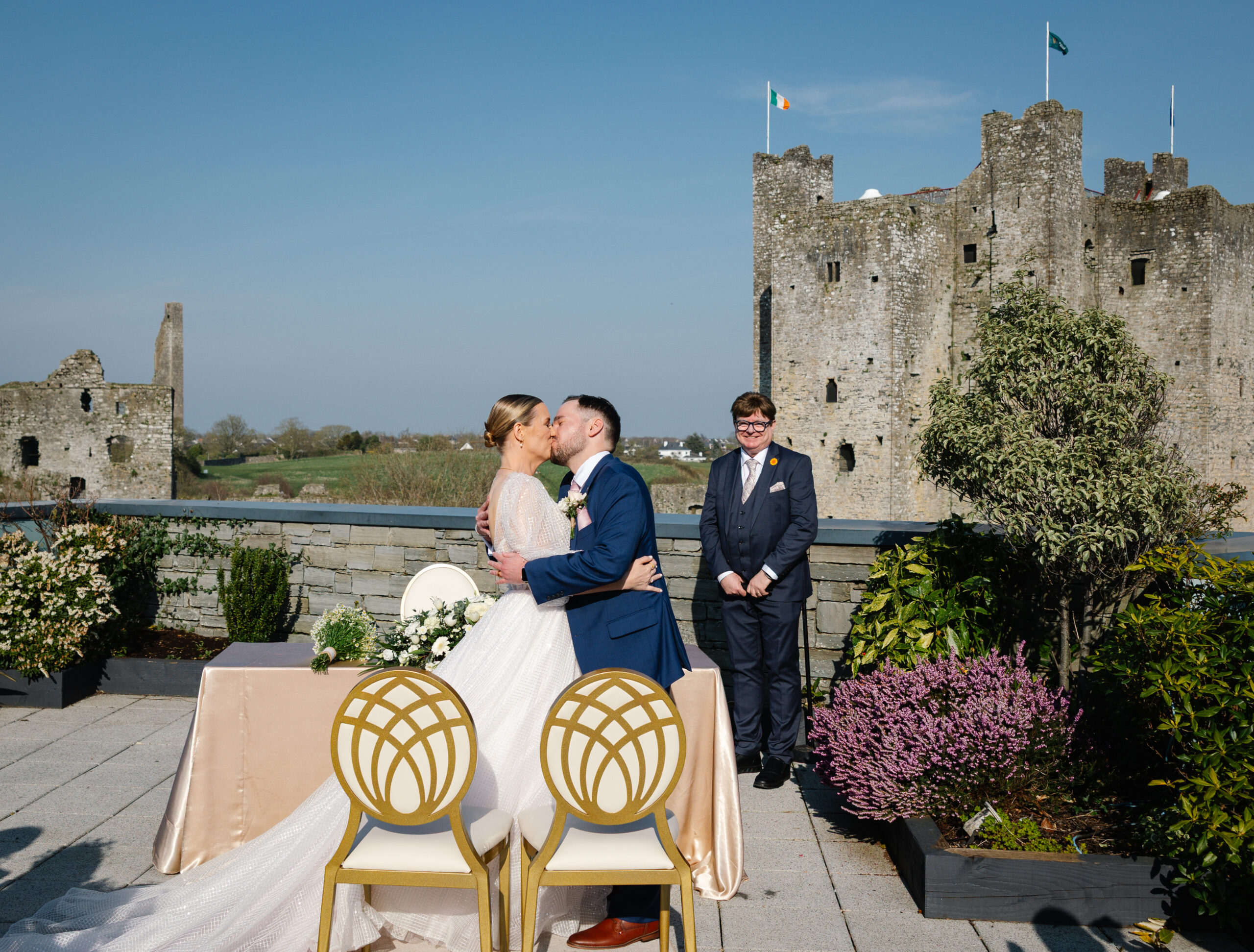 Bride and groom kissing at an outdoor castle wedding ceremony