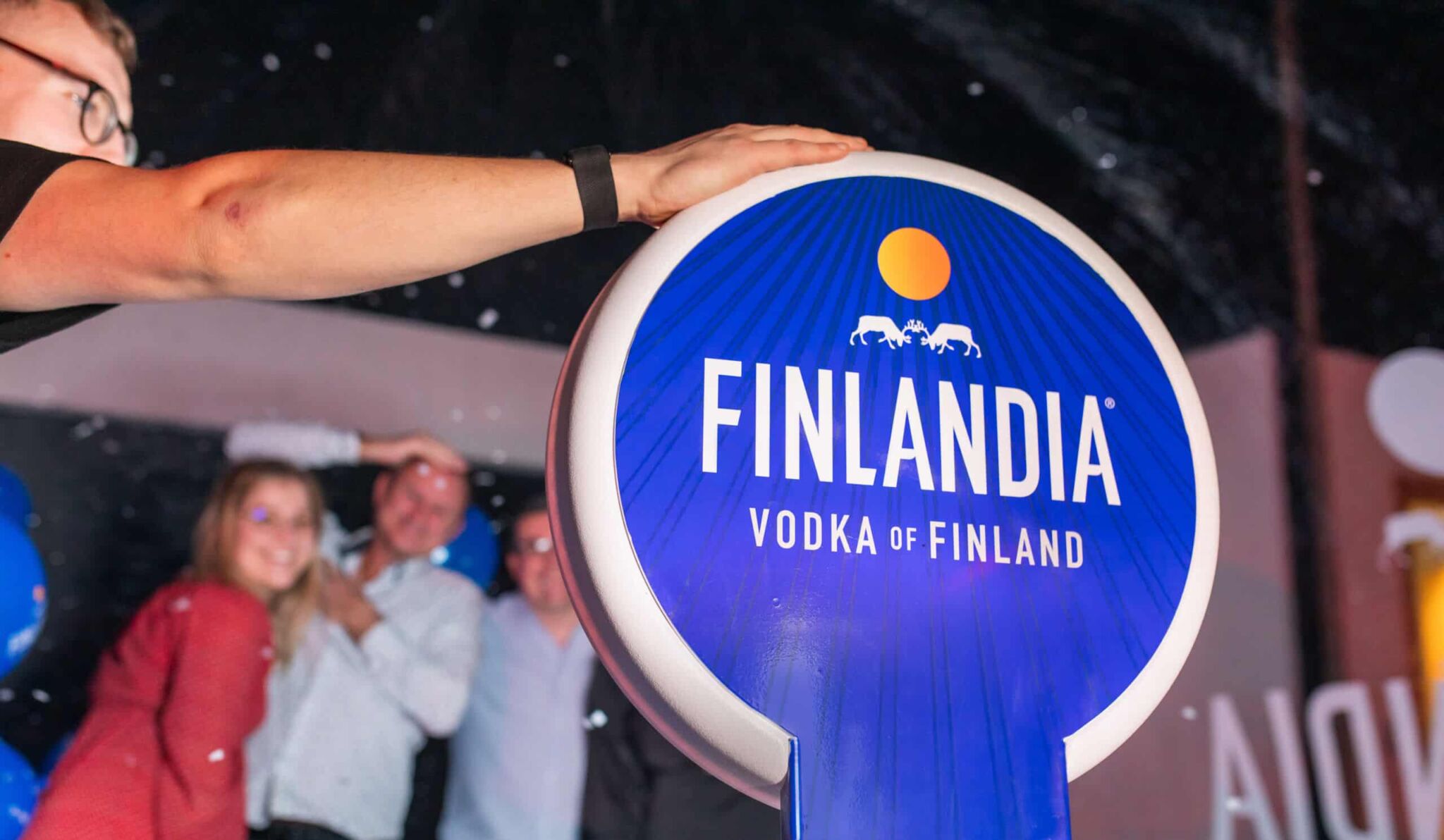 Guests posing in a branded vodka photo booth at a corporate event