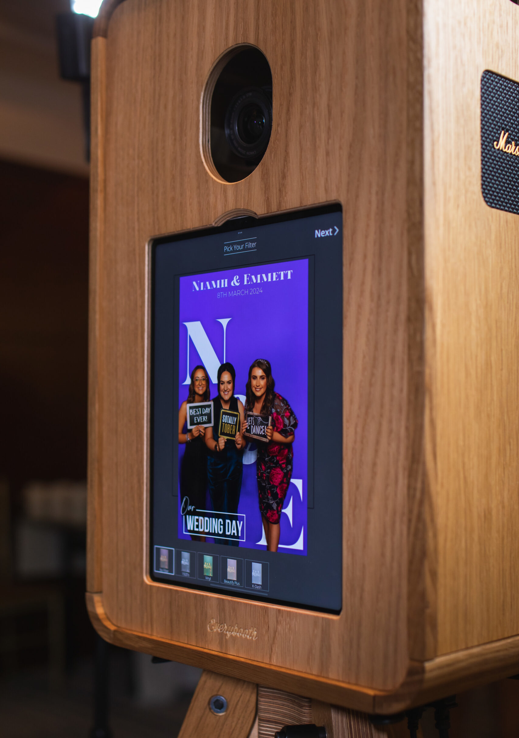 Photo booth touchscreen displaying a group photo with filter options