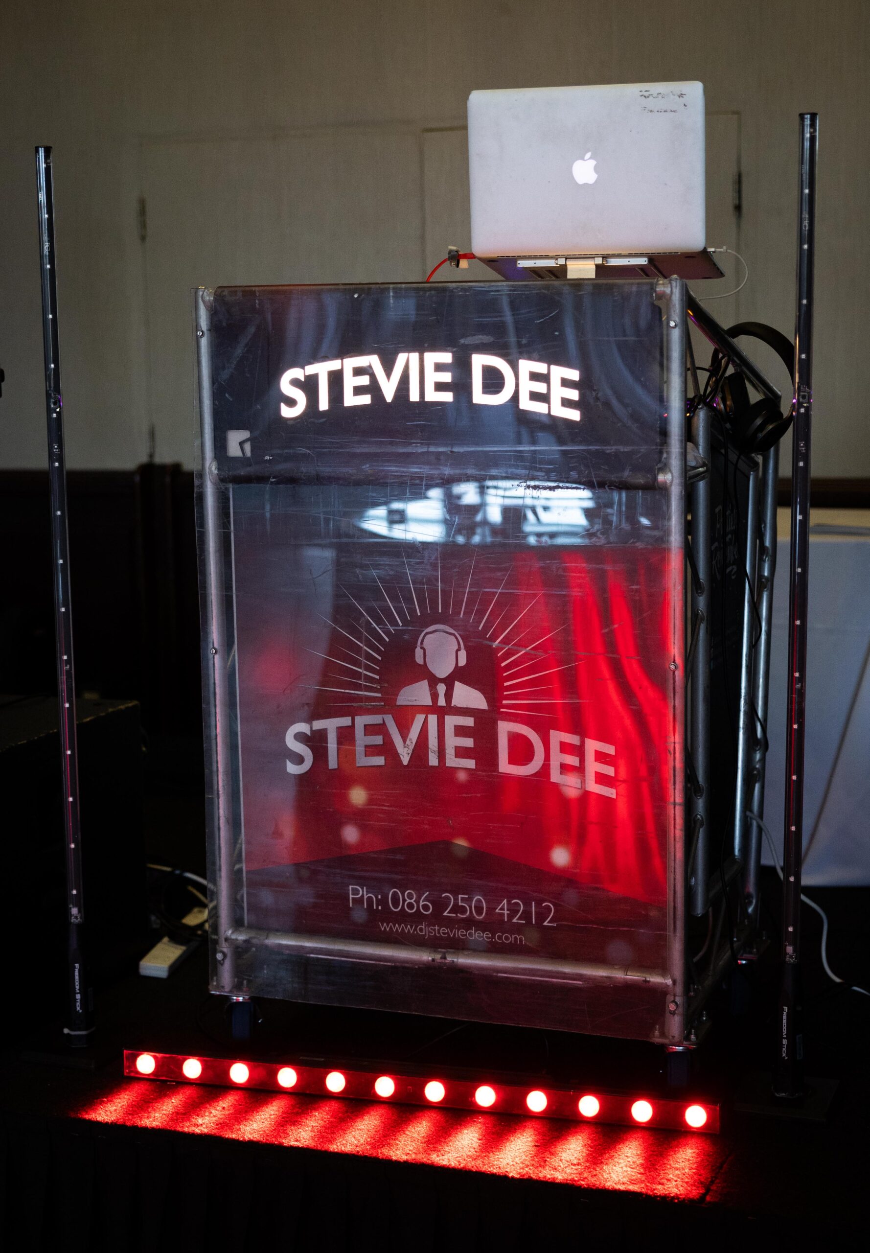 Stevie Dee DJ booth with red LED lighting and speaker stacks